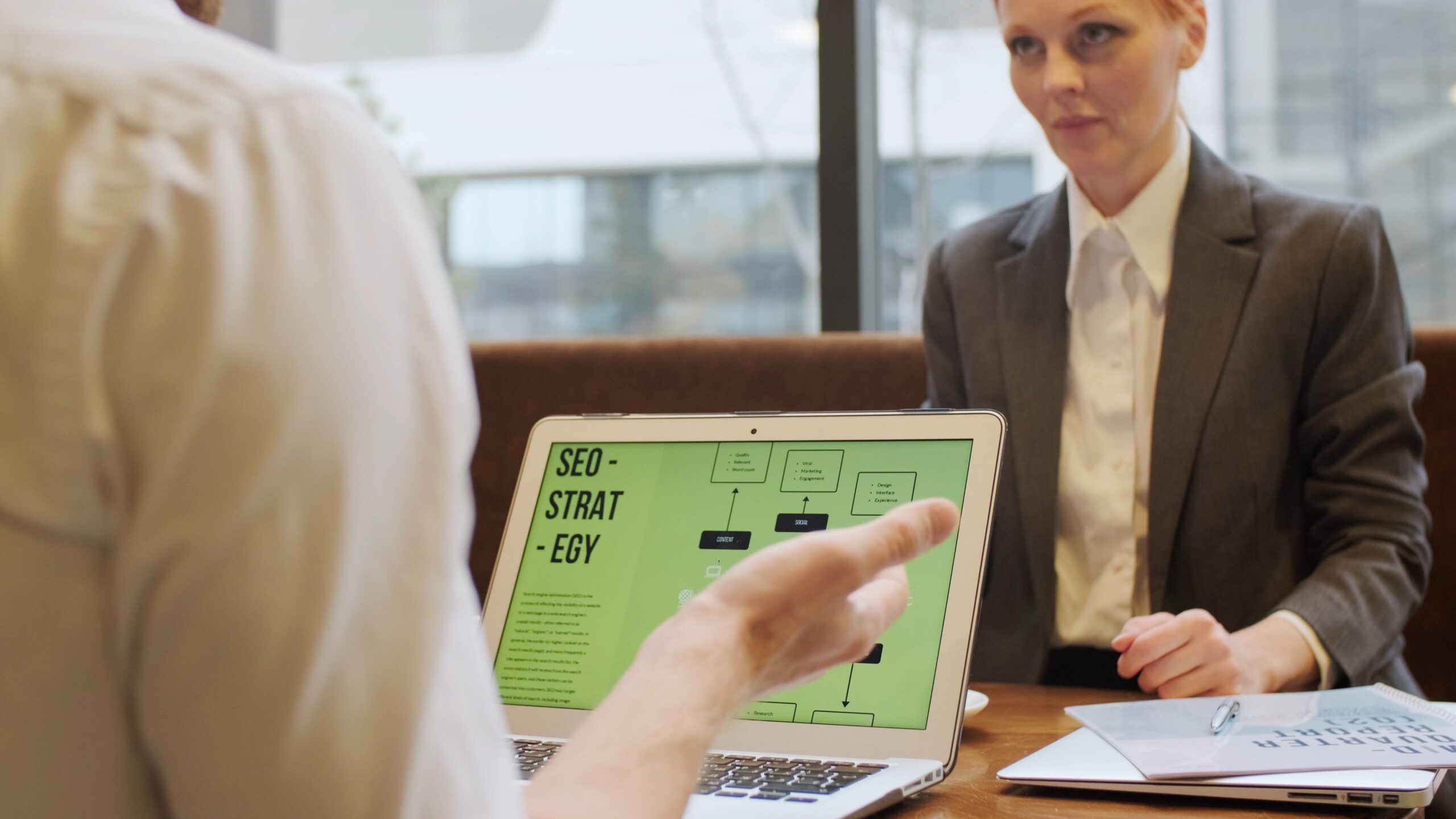 Consultant and client reviewing an SEO strategy on a laptop during a meeting