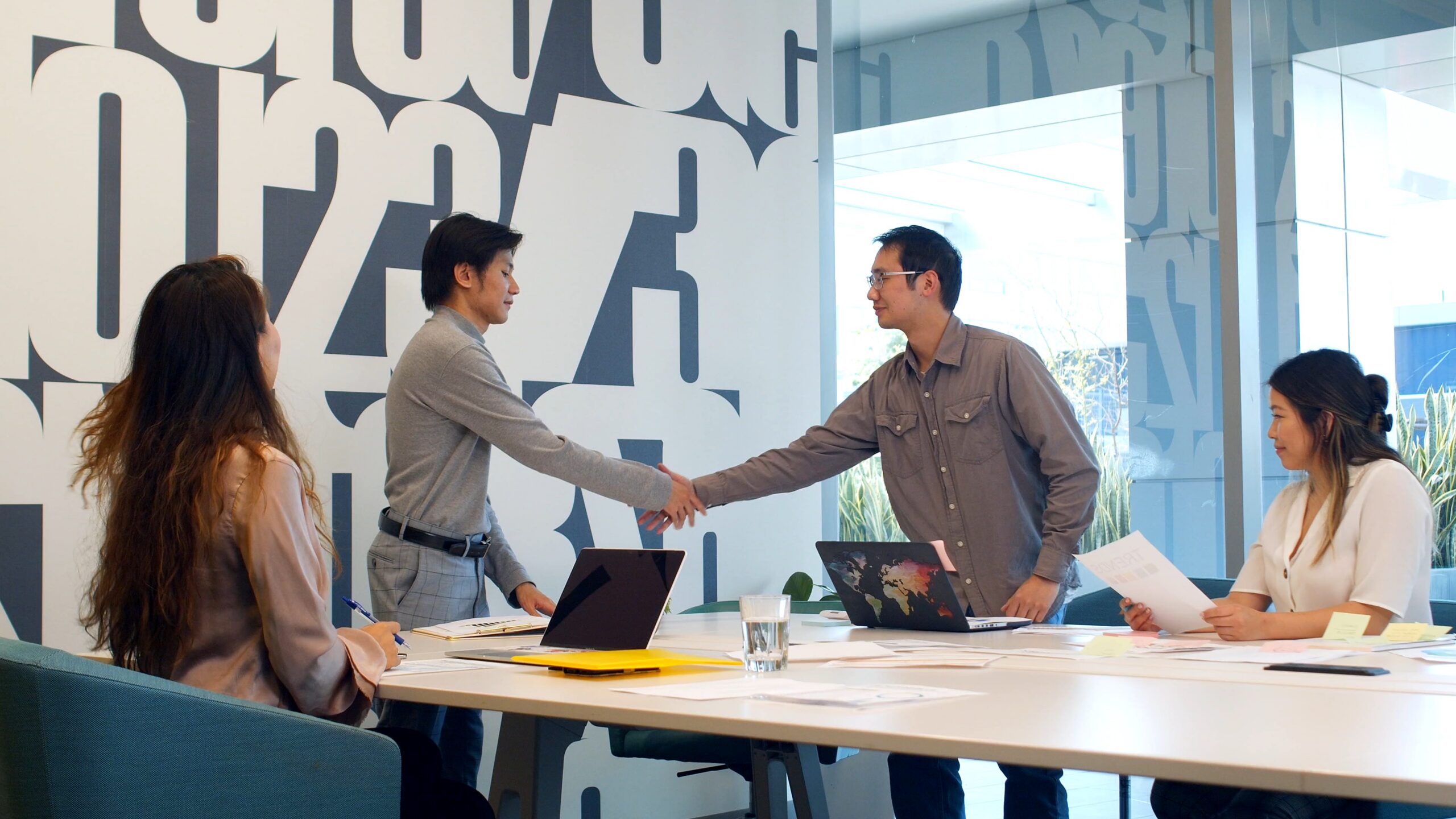 Business owner shaking hands with a digital marketing consultant across a meeting table