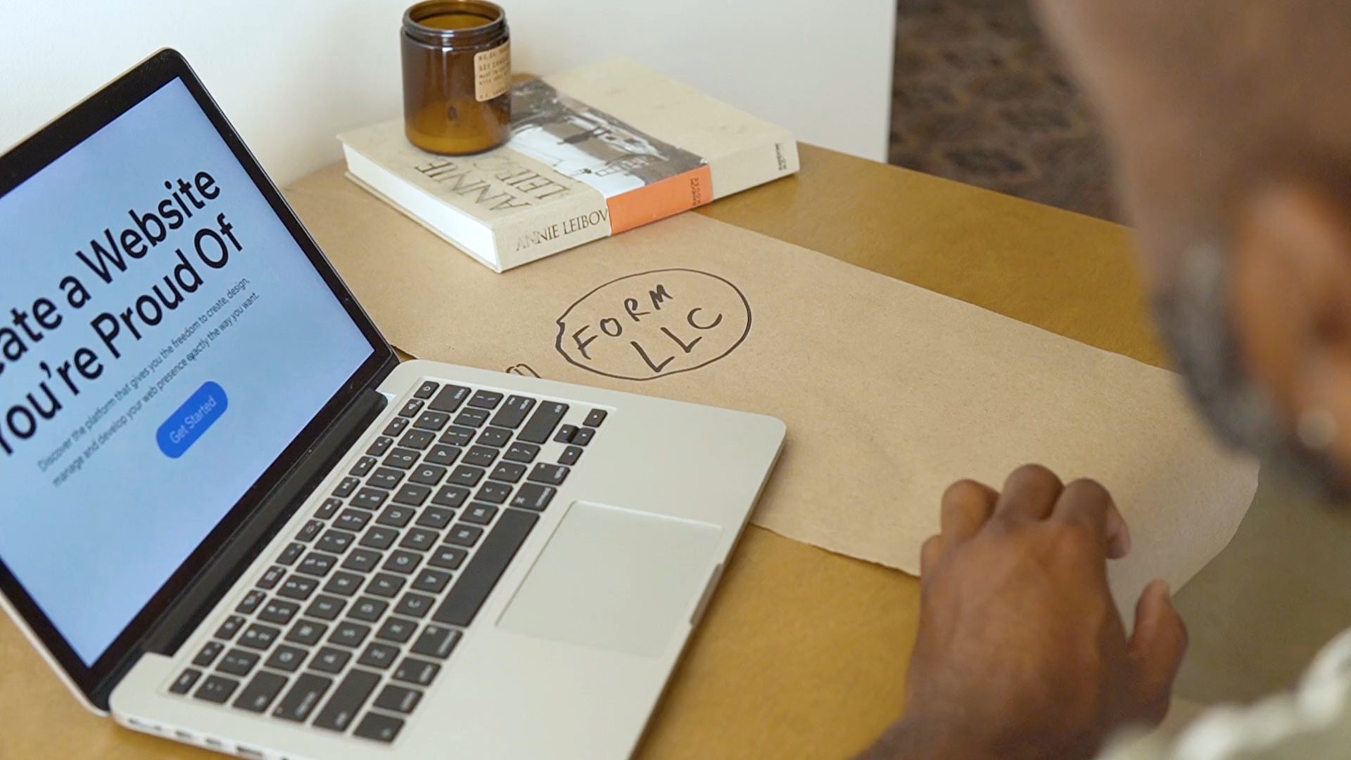 Laptop showing a website builder page on a wooden desk, illustrating website design services