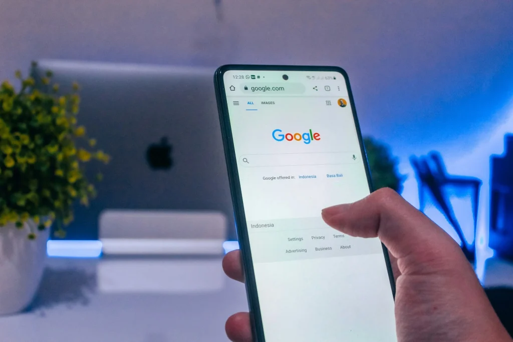 Hand holding a phone with Google search open, illustrating Google Ads landing pages