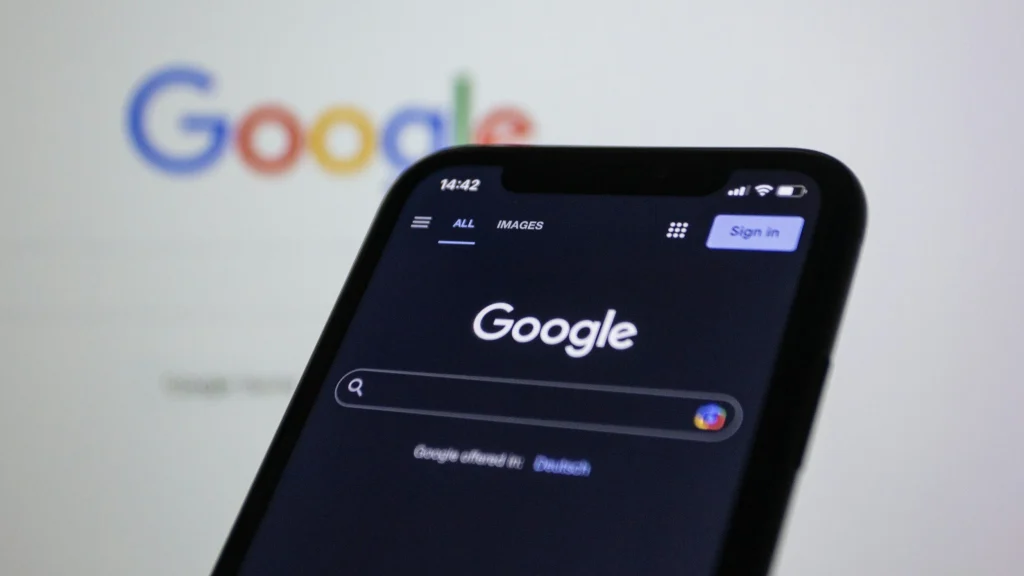 Phone showing the Google search app in front of a Google logo, comparing Google Ads vs SEO