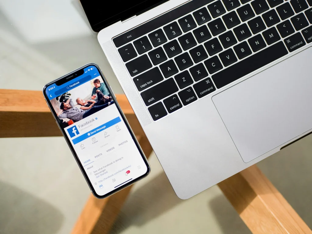 Phone showing Facebook beside a laptop, illustrating a Facebook retargeting strategy