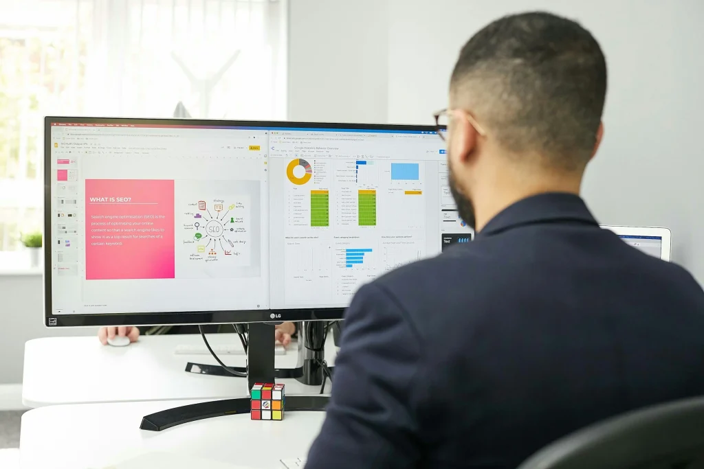 Person at a monitor reviewing a marketing dashboard, illustrating small business SEO
