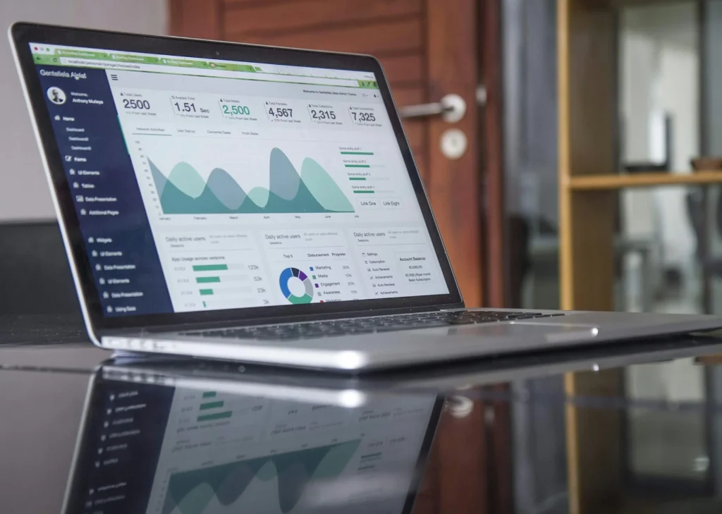 Laptop showing a website analytics dashboard with area charts, illustrating SEO content performance