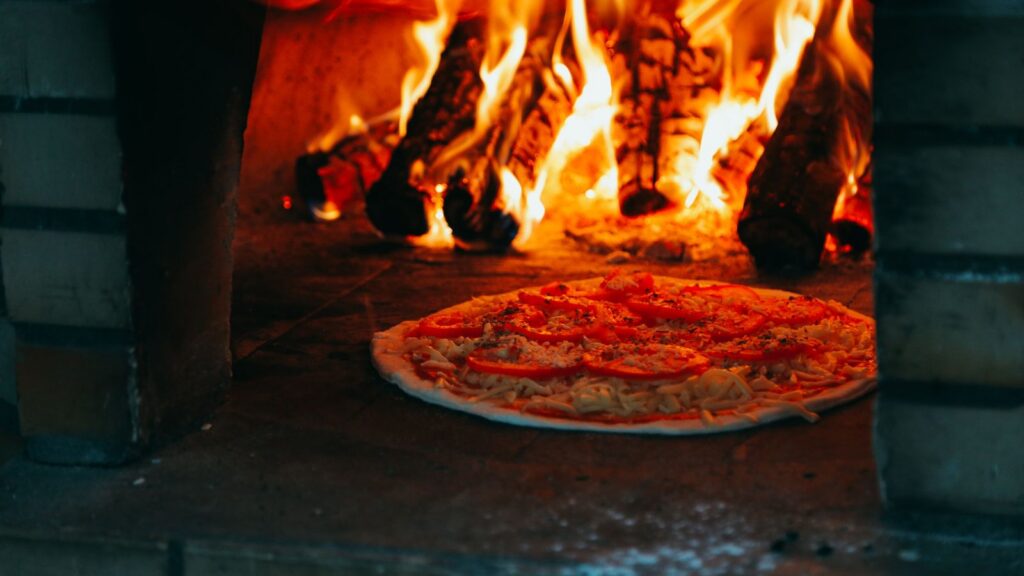 Pizza cooking in a wood-fired oven, for an article on profitable offers and Domino's pricing