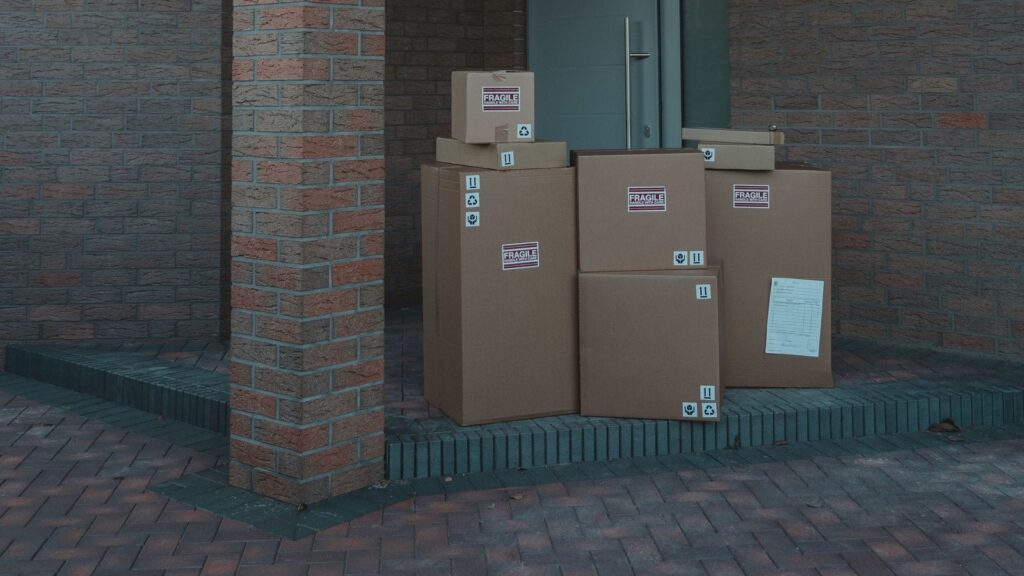 Stack of delivery boxes at a front door, illustrating why your own customer list matters as marketplaces grow