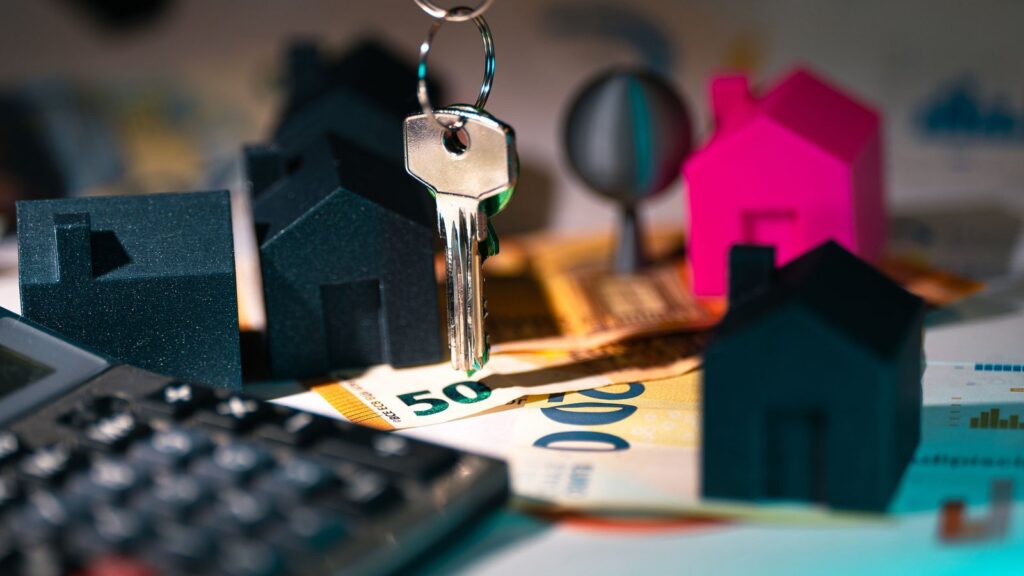 House keys and model houses beside a calculator and cash, illustrating rate rises in 2026