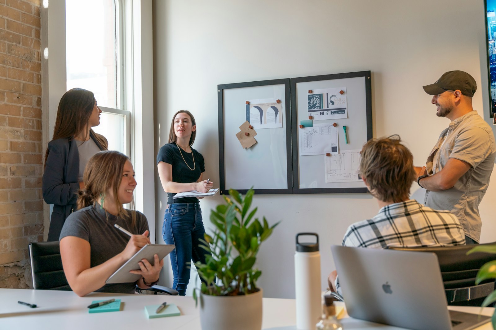 Small team in a strategy session at a whiteboard in a bright office